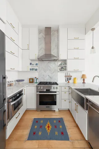 a kitchen with stainless steel appliances kitchen island a table chairs and wooden floor