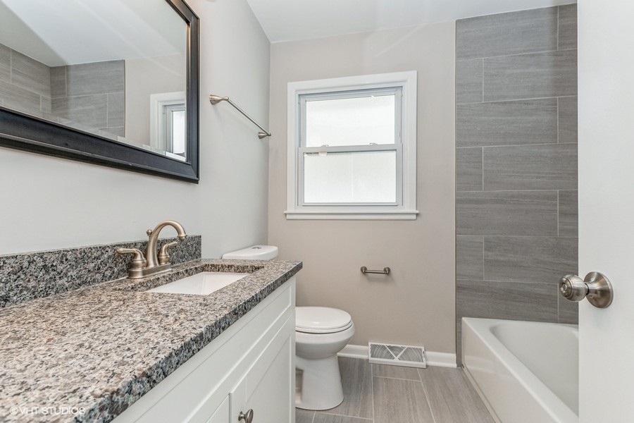 3914 153rd Street Midlothian, IL 60445 - Photo 11 of 17 a bathroom with a granite countertop sink a toilet and bathtub