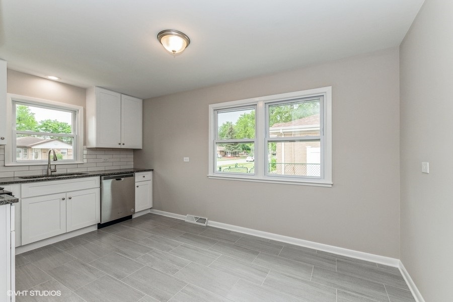 3914 153rd Street Midlothian, IL 60445 - Photo 6 of 17 a kitchen with granite countertop white cabinets and wooden floor