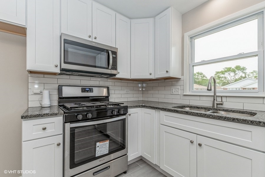 3914 153rd Street Midlothian, IL 60445 - Photo 7 of 17 a kitchen with granite countertop white cabinets appliances and a window