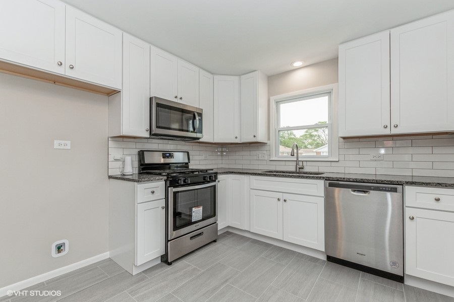 3914 153rd Street Midlothian, IL 60445 - Photo 8 of 17 a kitchen with granite countertop a stove top oven sink and cabinets