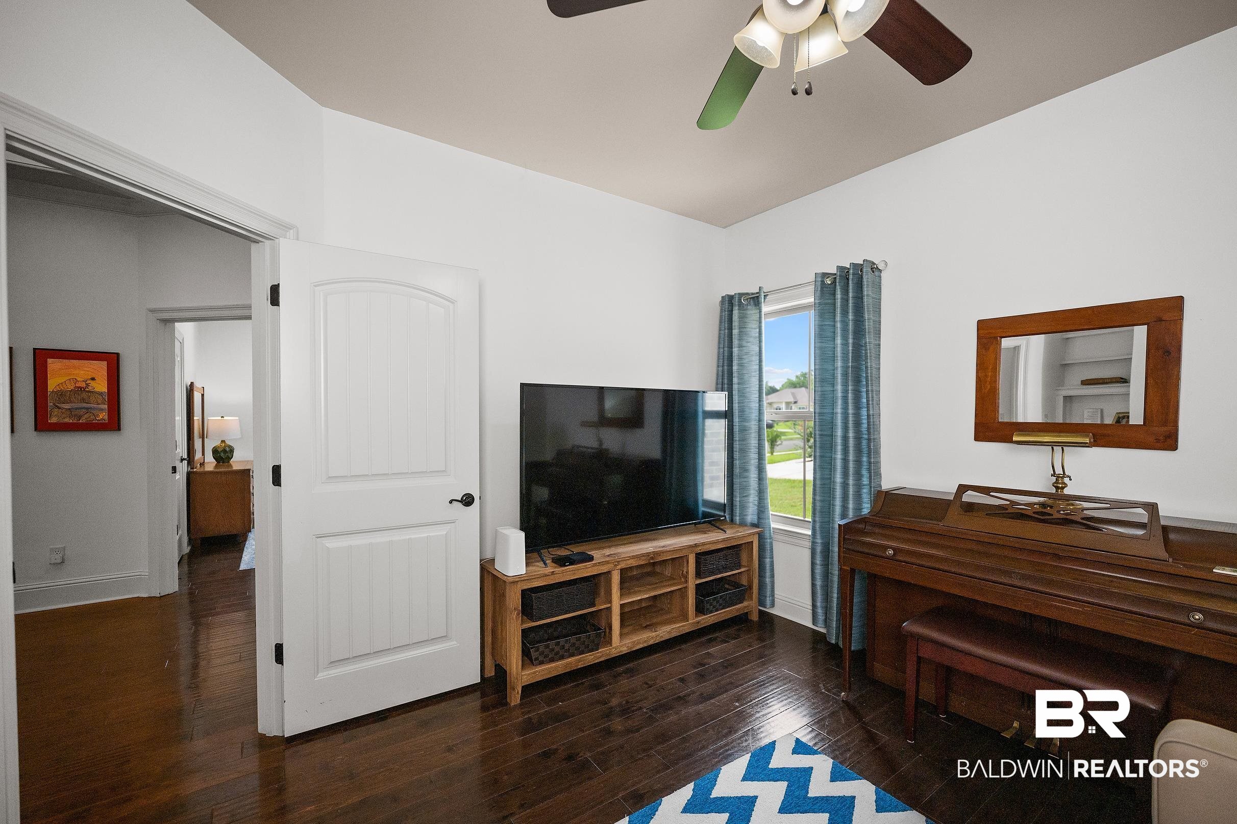 313 Pecan Ridge Boulevard Fairhope, AL 36532 - Photo 23 of 51 Spacious room with dark wood-finish flooring, white walls, and vaulted ceilings