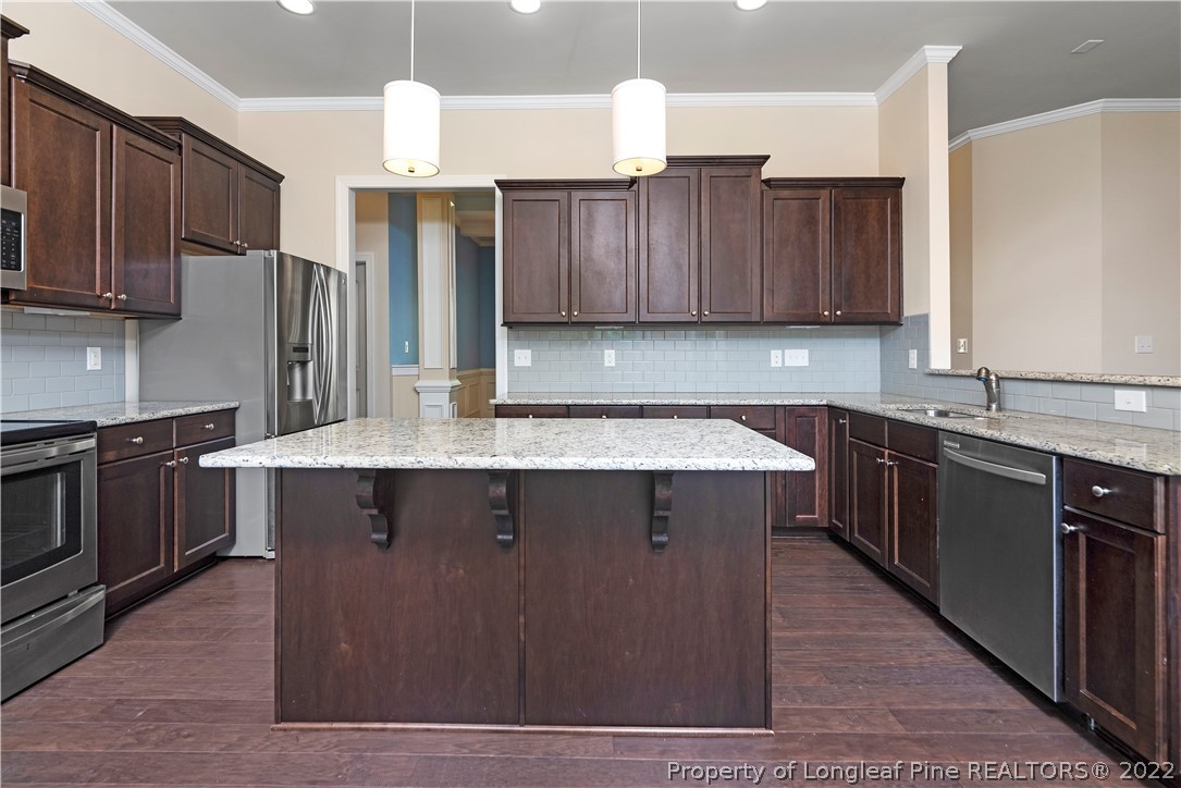 303 Falling Water Road Spring Lake, NC 28390 - Photo 17 of 33 a kitchen with stainless steel appliances granite countertop a stove a sink dishwasher a refrigerator and wooden cabinets with wooden floor