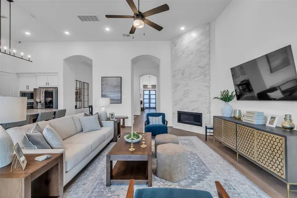 a large white kitchen with a large island oven a stove a sink a dining table and chairs