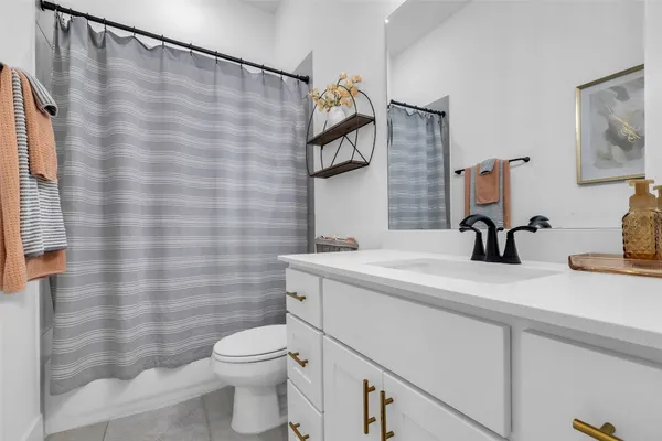 a large kitchen with kitchen island a large counter top space a sink a large window stainless steel appliances and cabinets