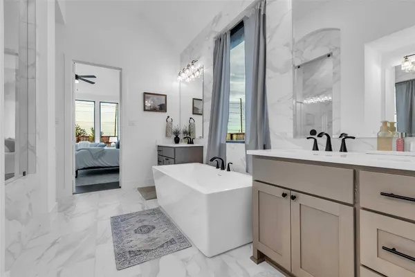 a spacious bathroom with a tub sink and mirror