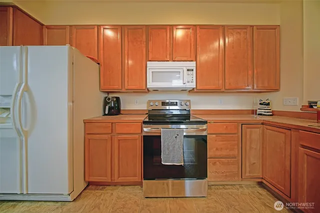 a kitchen with stainless steel appliances granite countertop a refrigerator a stove a sink and a refrigerator