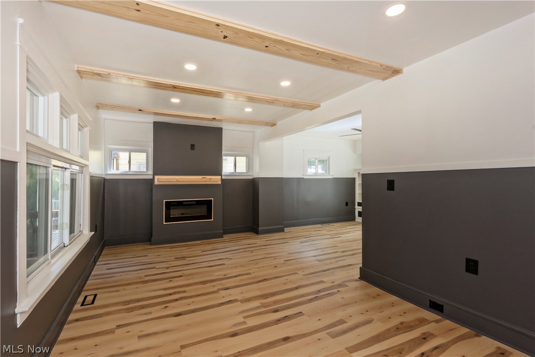 Living room with beamed ceilings, recessed lighting, 
Luxury LVT flooring and a custom electric fireplace