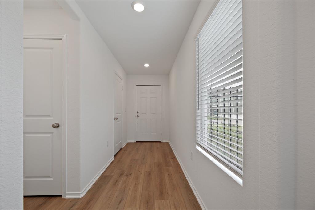 12213 Rising Moon Lane Del Valle, TX 78617 - Photo 2 of 11 wooden floor in an empty room with a window