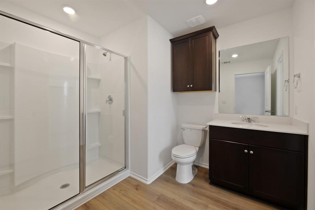 12213 Rising Moon Lane Del Valle, TX 78617 - Photo 8 of 11 a bathroom with a double vanity sink toilet and shower