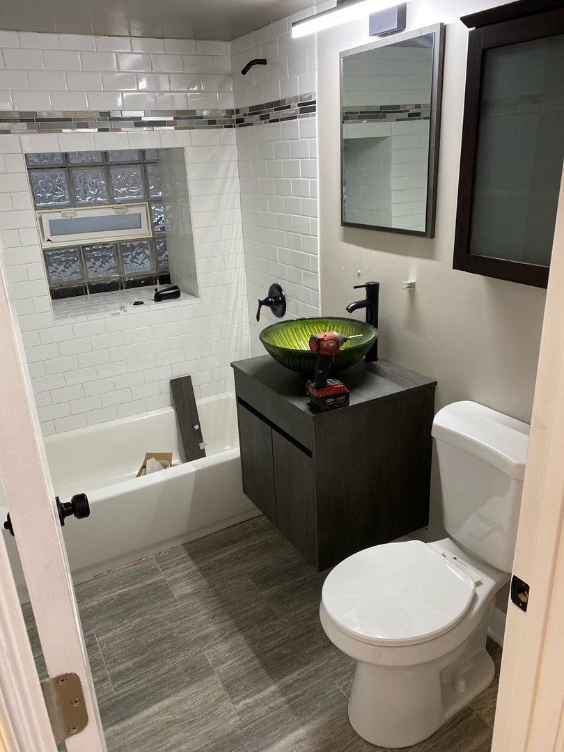 2122 North Keystone Avenue, Unit G Chicago, IL 60639 - Photo 3 of 4 a bathroom with a toilet a sink and a mirror