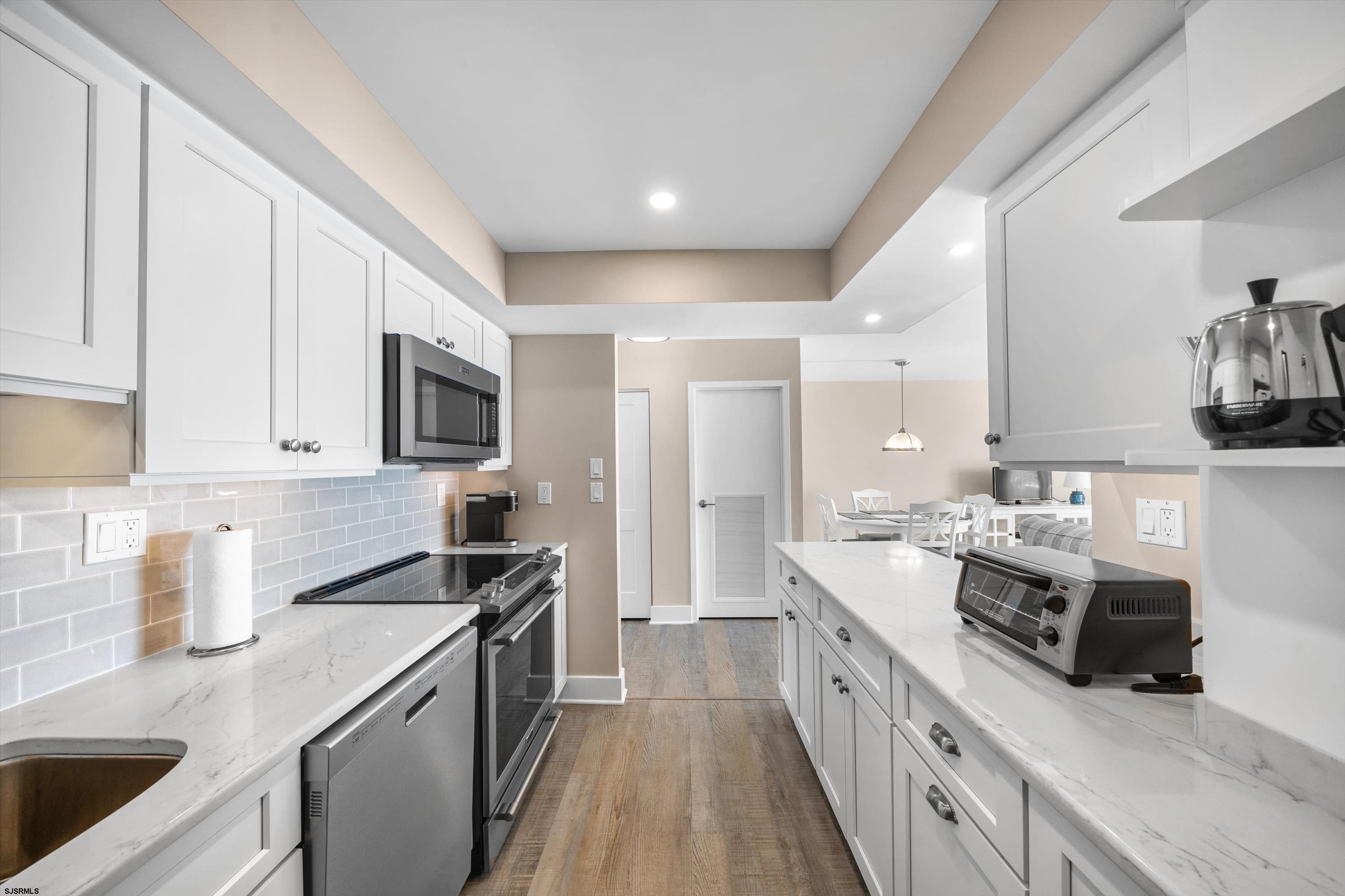 322 Boardwalk, Unit 1007 Ocean City, NJ 08226 - Photo 6 of 27 a kitchen with stainless steel appliances granite countertop a sink stove and refrigerator
