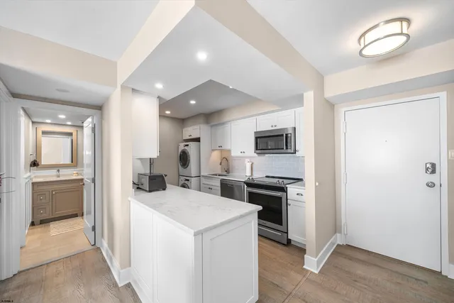 a kitchen with a sink stainless steel appliances furniture and a window