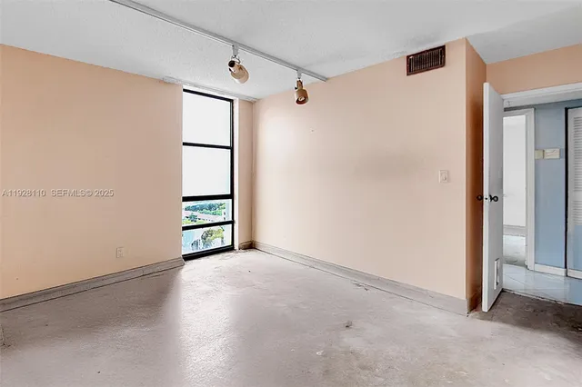 an empty room with windows and cabinet