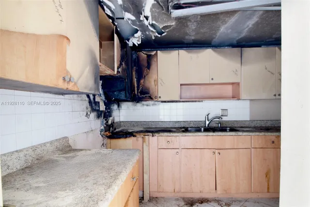 a kitchen with granite countertop a sink a stove and cabinets