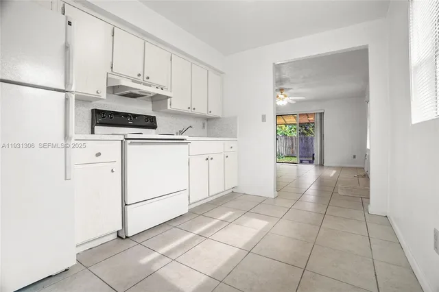 a kitchen with stainless steel appliances granite countertop a refrigerator sink and white cabinets