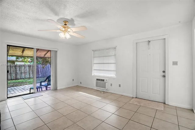 a view of empty room with cabinet and fan