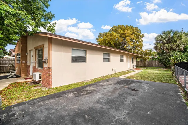 a view of a house with backyard and trees