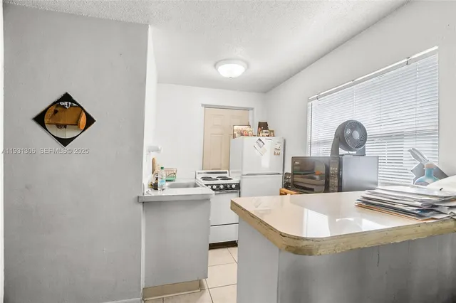 a kitchen with kitchen island stainless steel appliances a sink and living room view