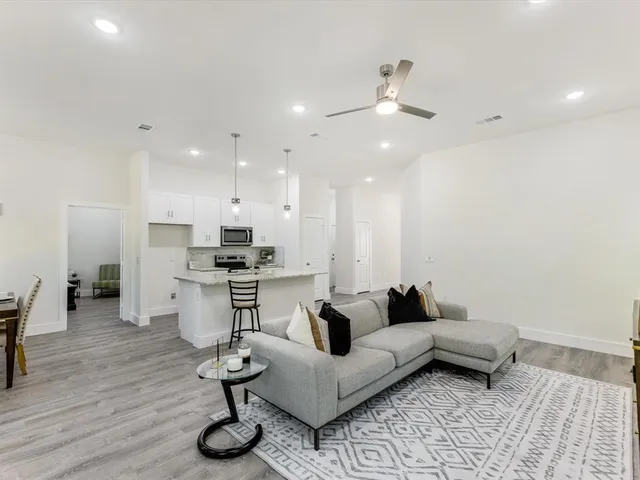 a living room with furniture and kitchen view