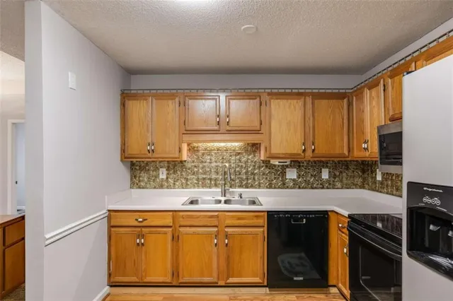 a kitchen with a refrigerator sink and cabinets