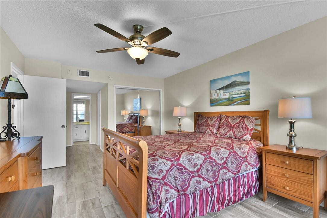 2601 South Course Drive, Unit 409 Pompano Beach, FL 33069 - Photo 12 of 58 a bedroom with a large bed and a chandelier