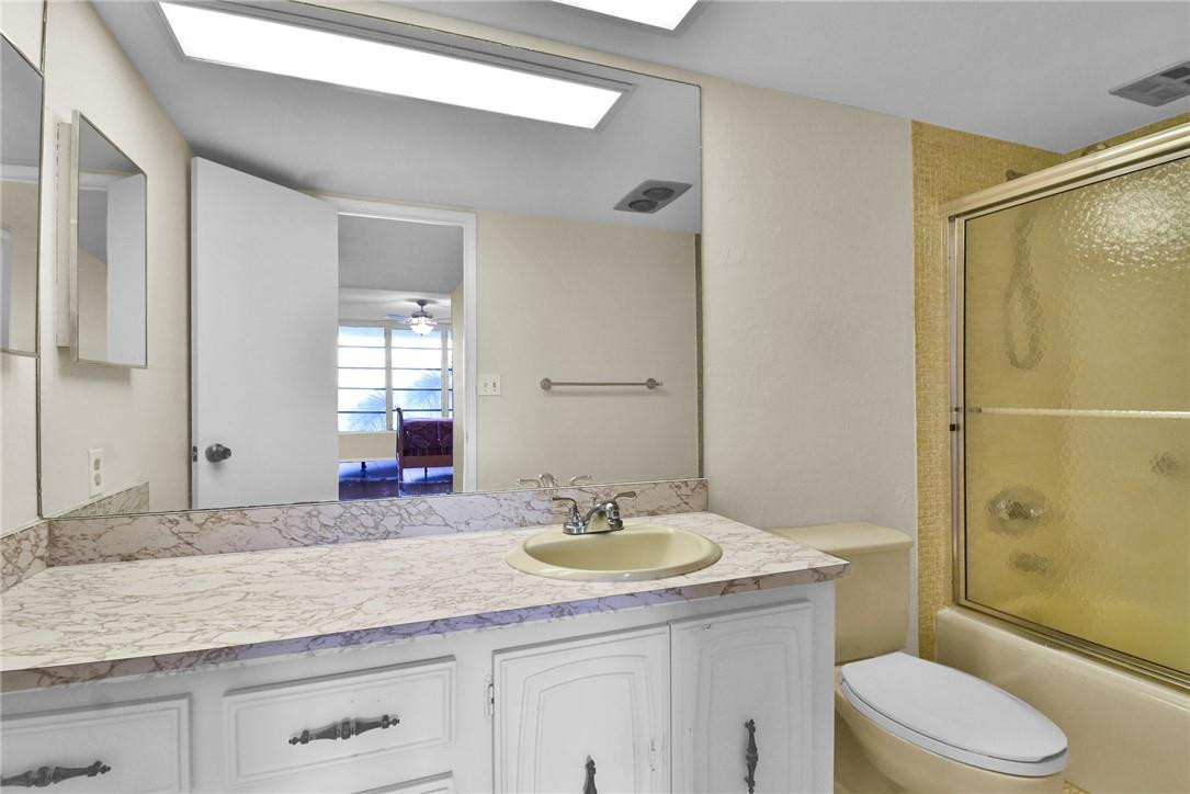 2601 South Course Drive, Unit 409 Pompano Beach, FL 33069 - Photo 15 of 58 a bathroom with a granite countertop sink toilet and shower