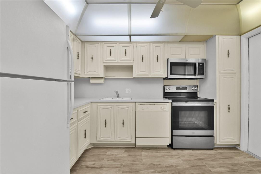 2601 South Course Drive, Unit 409 Pompano Beach, FL 33069 - Photo 18 of 58 a kitchen with stainless steel appliances a refrigerator stove and white cabinets