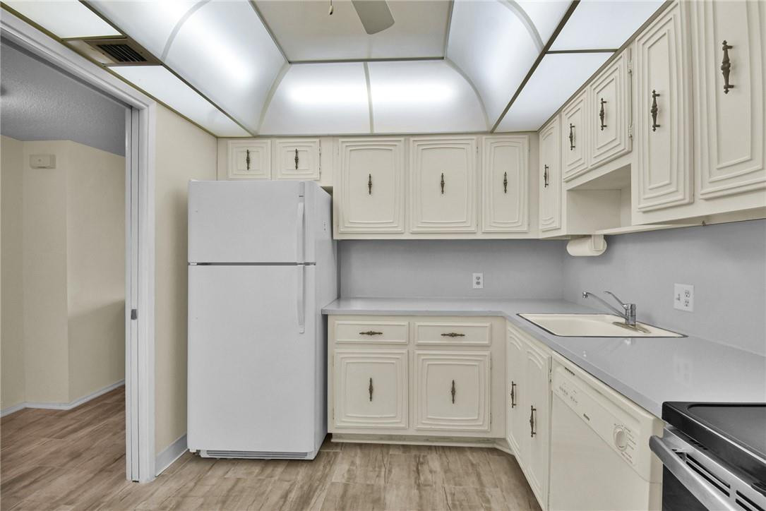 2601 South Course Drive, Unit 409 Pompano Beach, FL 33069 - Photo 19 of 58 a kitchen with white cabinets and white appliances