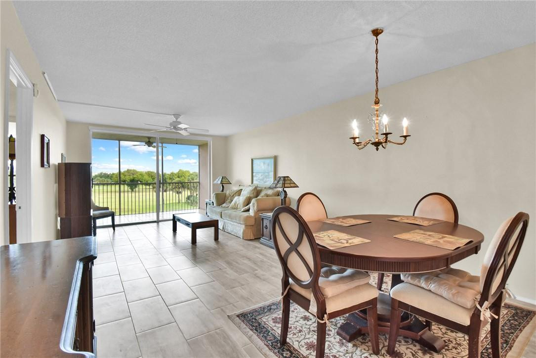 2601 South Course Drive, Unit 409 Pompano Beach, FL 33069 - Photo 2 of 58 a view of a dining room with furniture wooden floor and chandelier