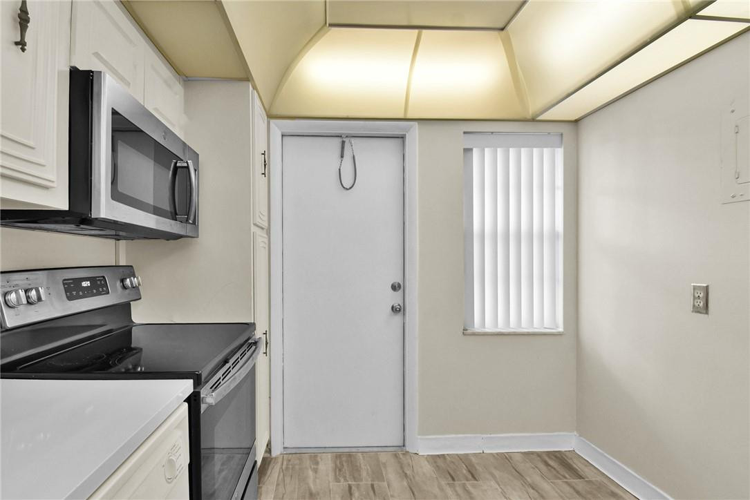 2601 South Course Drive, Unit 409 Pompano Beach, FL 33069 - Photo 21 of 58 a kitchen with a stove and a microwave