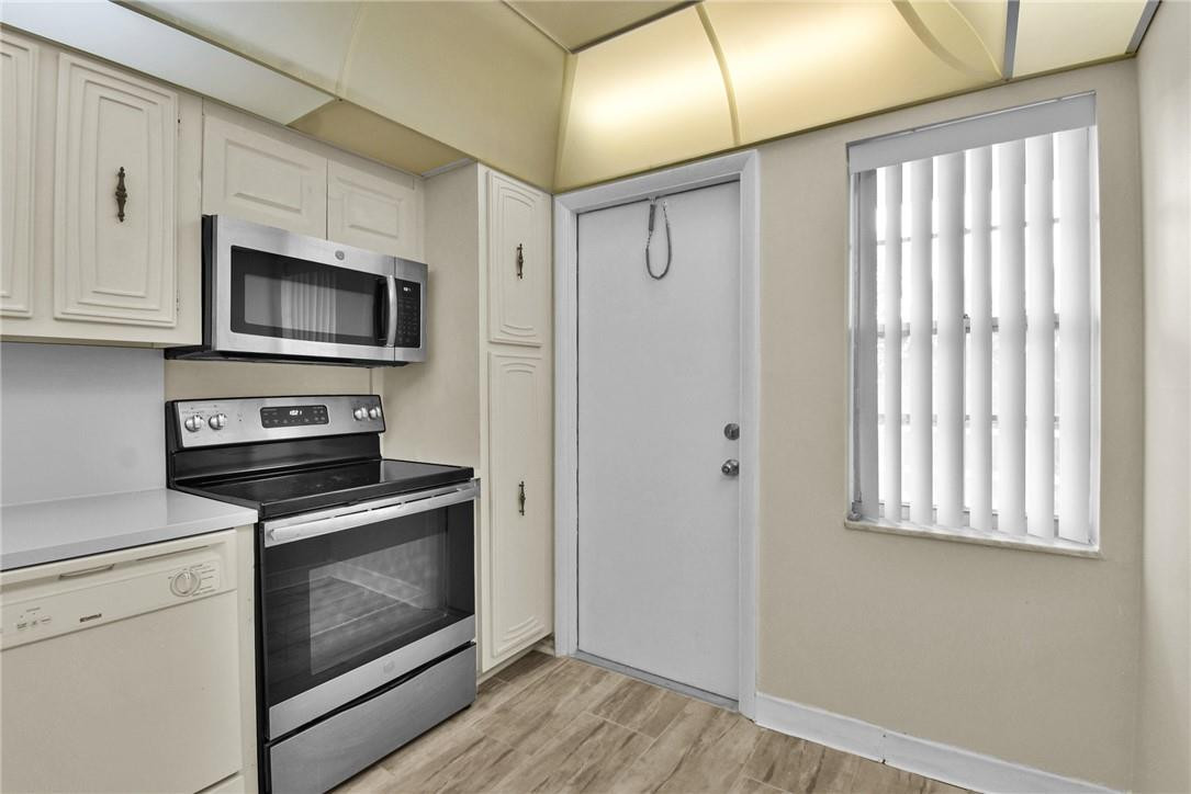 2601 South Course Drive, Unit 409 Pompano Beach, FL 33069 - Photo 22 of 58 a kitchen with granite countertop cabinets stainless steel appliances and a window