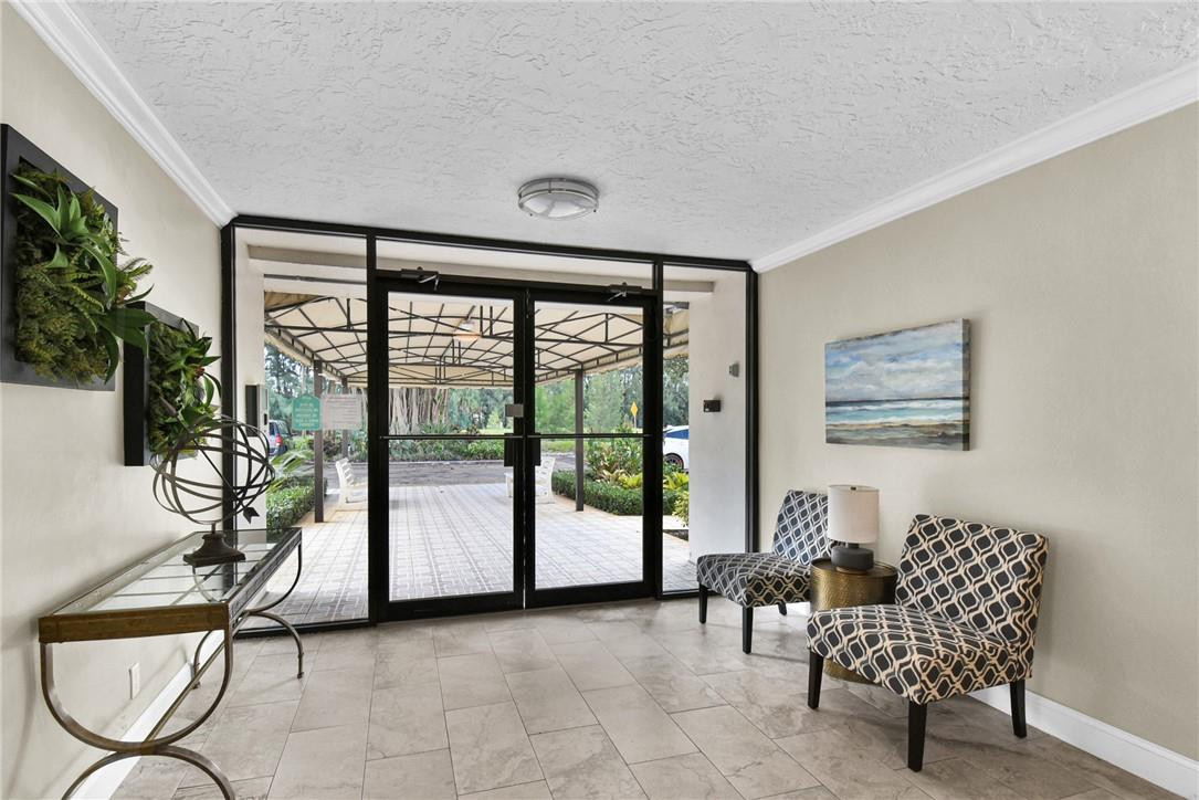 2601 South Course Drive, Unit 409 Pompano Beach, FL 33069 - Photo 30 of 58 a living room with furniture and floor to ceiling window