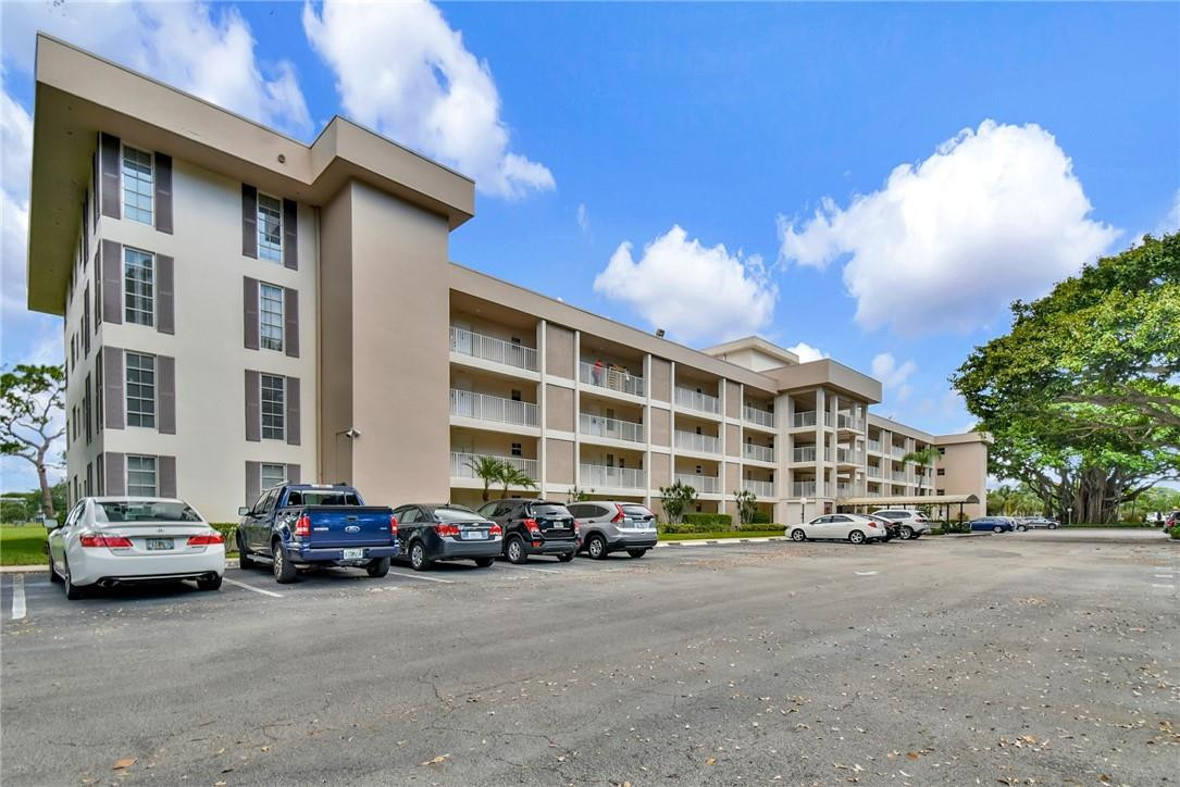 2601 South Course Drive, Unit 409 Pompano Beach, FL 33069 - Photo 40 of 58 a car parked in front of a building