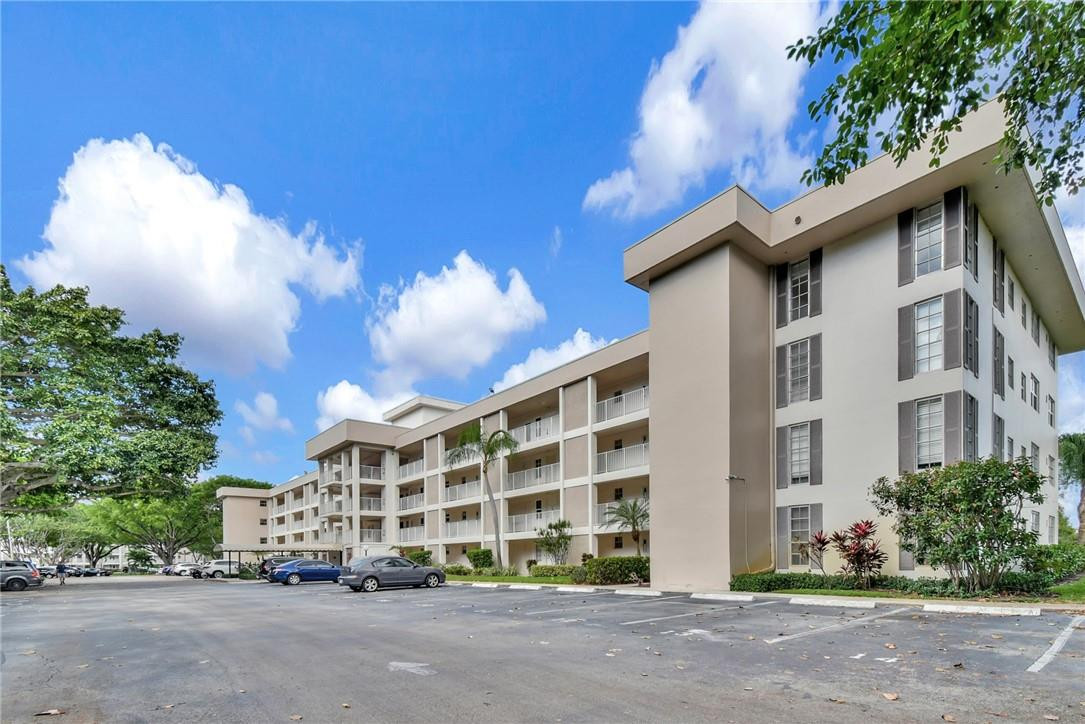 2601 South Course Drive, Unit 409 Pompano Beach, FL 33069 - Photo 45 of 58 a city street lined with buildings and trees