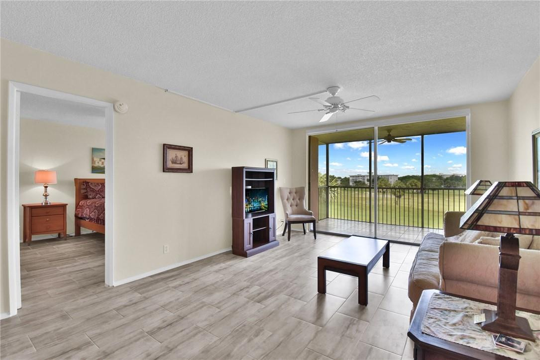 2601 South Course Drive, Unit 409 Pompano Beach, FL 33069 - Photo 7 of 58 a living room filled with furniture and a floor to ceiling window