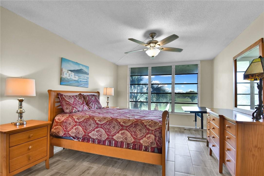 2601 South Course Drive, Unit 409 Pompano Beach, FL 33069 - Photo 10 of 58 a bedroom with a bed window and couch