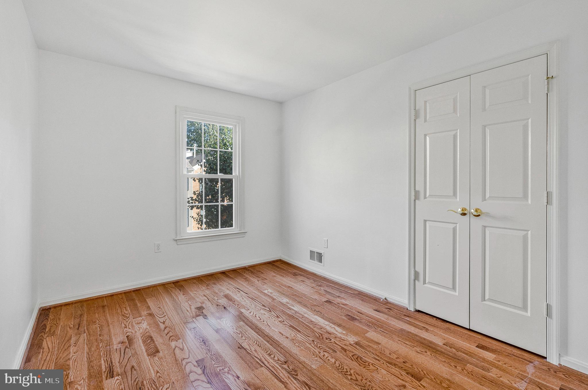 2043 Pieris Court Vienna, VA 22182 - Photo 20 of 43 a view of an empty room with wooden floor and a window