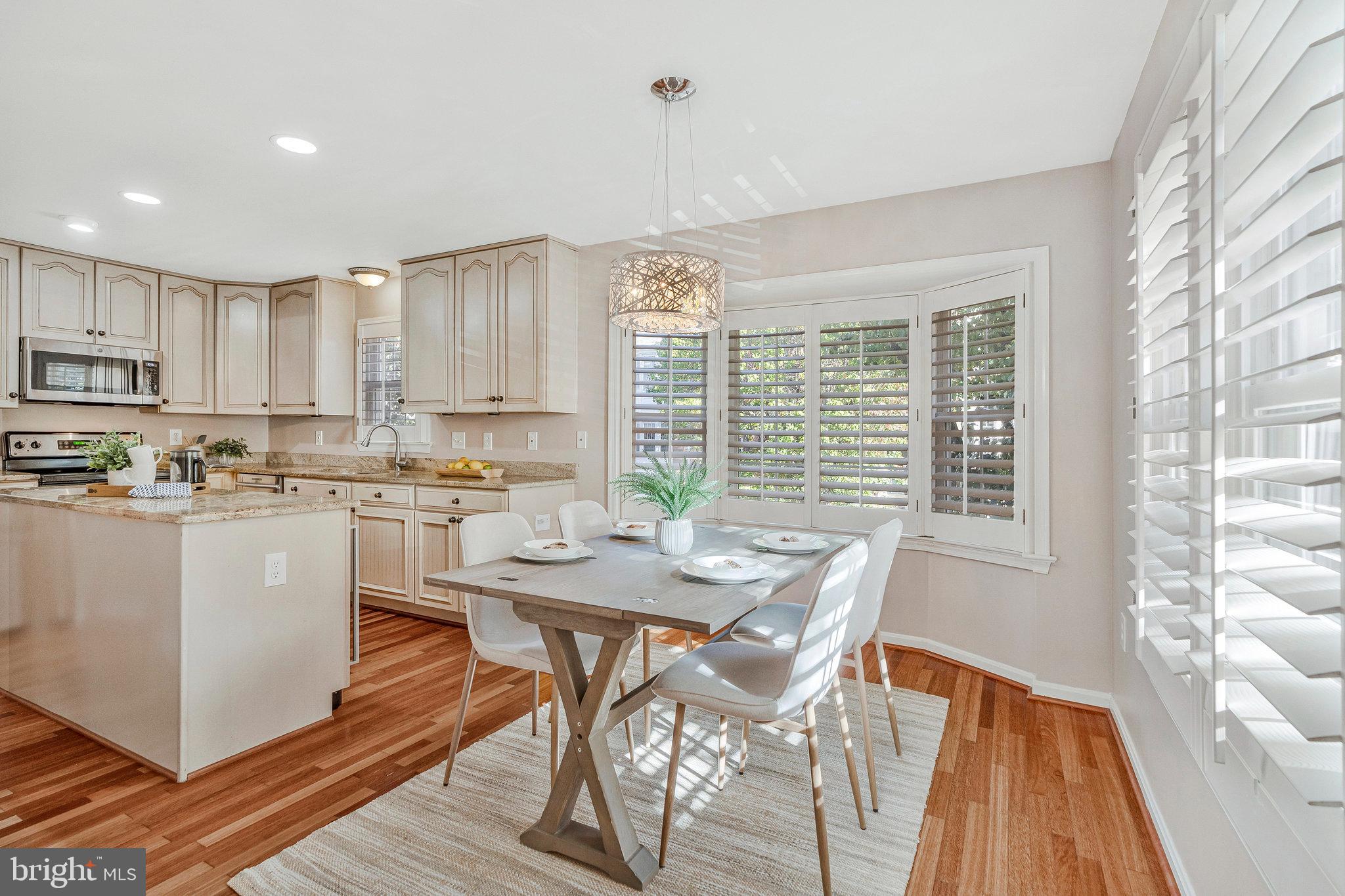 2043 Pieris Court Vienna, VA 22182 - Photo 9 of 43 a kitchen with stainless steel appliances granite countertop a stove a sink a microwave a dining table and chairs