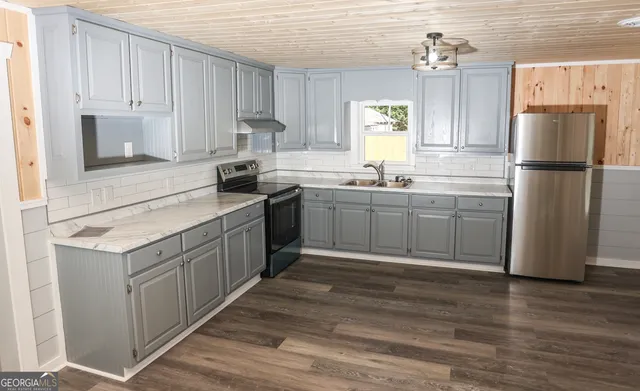 a kitchen with stainless steel appliances granite countertop a sink stove and refrigerator