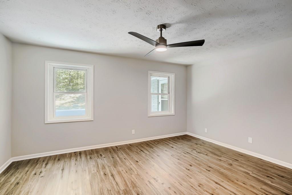 2021 Irwin Bridge Road Northwest Conyers, GA 30012 - Photo 25 of 43 a view of empty room with wooden floor and fan