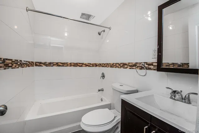 a bathroom with a granite countertop sink a toilet and shower