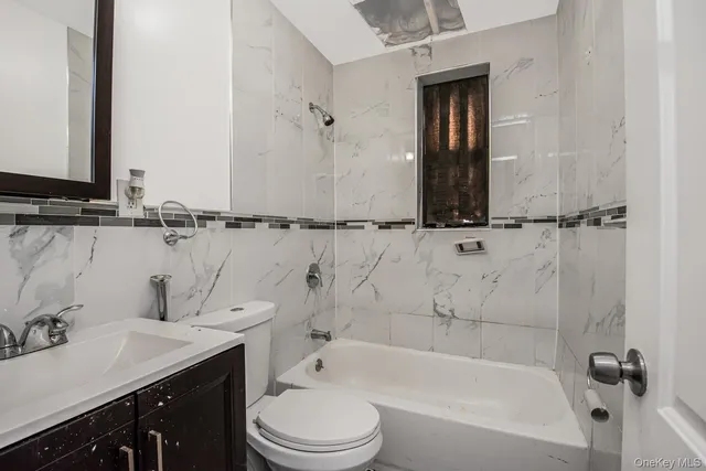 a bathroom with a granite countertop sink a toilet and shower