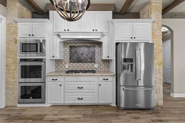 a kitchen with stainless steel appliances a stove a microwave and a refrigerator