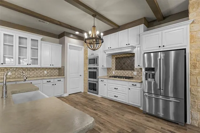 a large kitchen with stainless steel appliances granite countertop a stove and cabinets