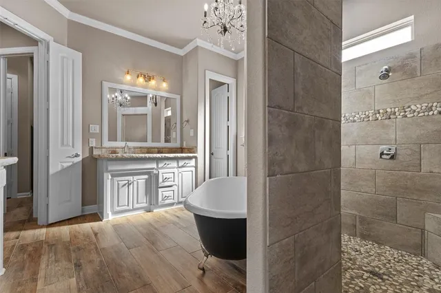 a view of an empty room with wooden floor and a ceiling fan