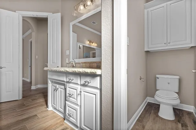 a spacious bathroom with a granite countertop sink a toilet and shower