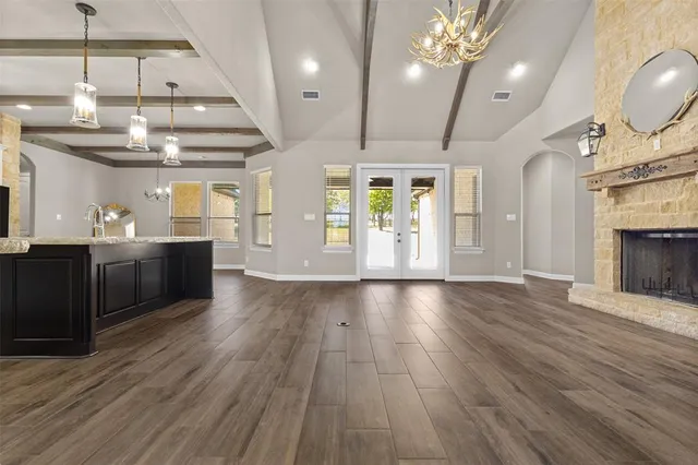 a view of a room with stainless steel appliances wooden floors and chandelier
