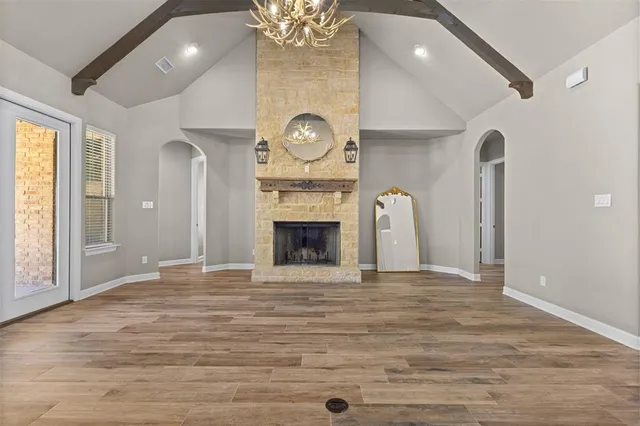 a view of an empty room with a fireplace and a window
