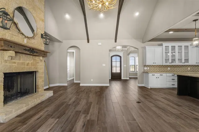 a view of a hallway with entryway a fireplace and wooden floor
